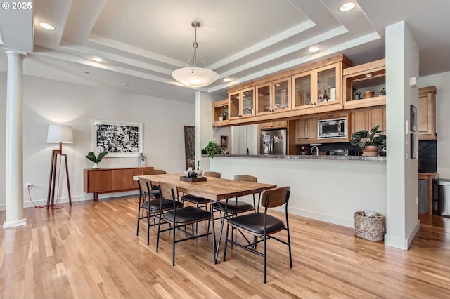844 SW Broadway Dr Unit 3, Portland, OR 97201 - dining space featuring a tray ceiling, ornate columns, recessed lighting, light wood-style floors, and baseboards