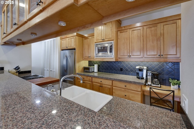 844 SW Broadway Dr Unit 3, Portland, OR 97201 - kitchen with stainless steel appliances, a sink, tasteful backsplash, and dark stone counters