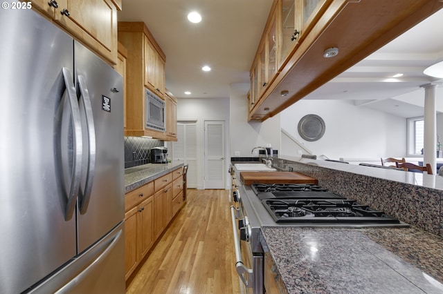 844 SW Broadway Dr Unit 3, Portland, OR 97201 - kitchen featuring stainless steel appliances, decorative backsplash, glass insert cabinets, recessed lighting, and light wood finished floors