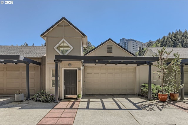 844 SW Broadway Dr Unit 3, Portland, OR 97201 - view of front of property with concrete driveway, an attached garage, and stucco siding