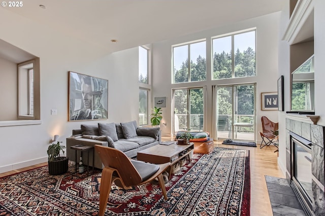 844 SW Broadway Dr Unit 3, Portland, OR 97201 - living area with healthy amount of natural light, wood finished floors, a towering ceiling, and a tile fireplace