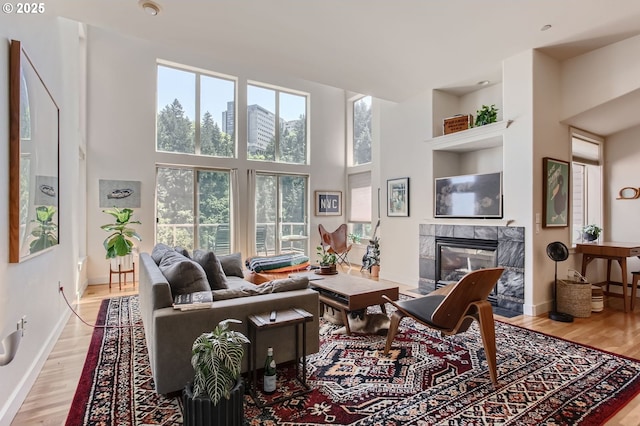 844 SW Broadway Dr Unit 3, Portland, OR 97201 - living room with a fireplace, a high ceiling, wood finished floors, and baseboards