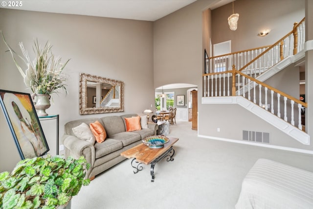 2678 SE Myrtlewood Way, Gresham, OR 97080 - carpeted living area with arched walkways, a high ceiling, a chandelier, stairs, and baseboards
