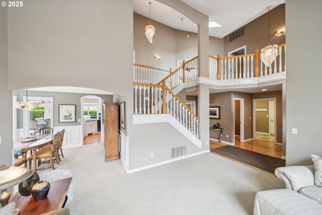 2678 SE Myrtlewood Way, Gresham, OR 97080 - carpeted living area featuring a high ceiling, arched walkways, a chandelier, stairway, and baseboards