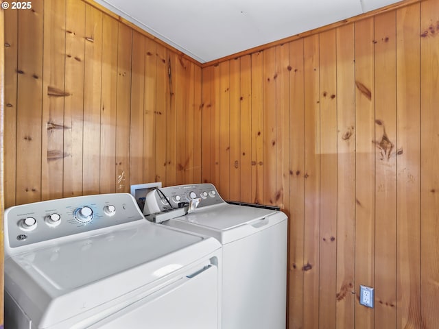 laundry area featuring laundry area, independent washer and dryer, and wood walls