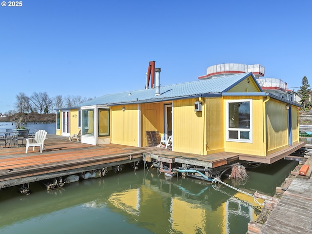 back of property with metal roof and a water view