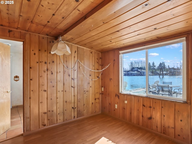 empty room with wooden walls, wood ceiling, and wood finished floors