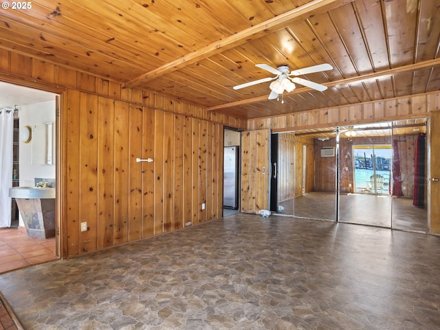 unfurnished living room featuring wooden ceiling, wood walls, and ceiling fan