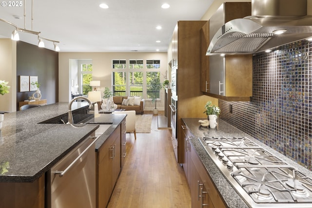 10122 SW Morrison St, Portland, OR 97225 - kitchen featuring stainless steel appliances, island exhaust hood, light wood finished floors, brown cabinets, and recessed lighting