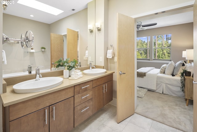 10122 SW Morrison St, Portland, OR 97225 - ensuite bathroom with double vanity, tile patterned flooring, a skylight, and a ceiling fan