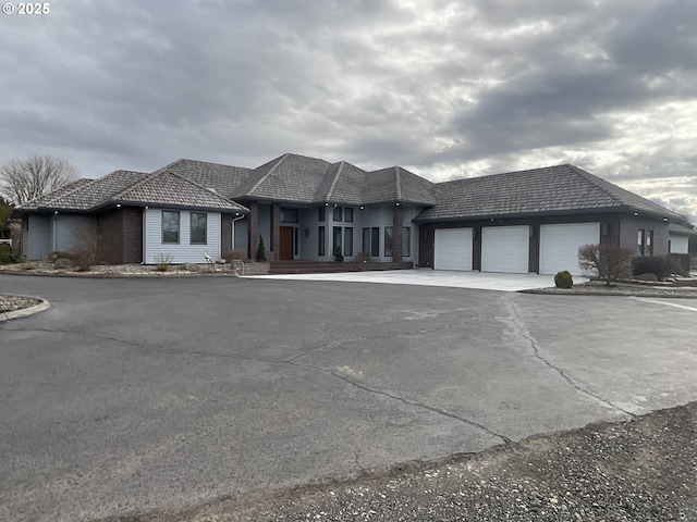 view of front facade featuring driveway, a garage, and brick siding