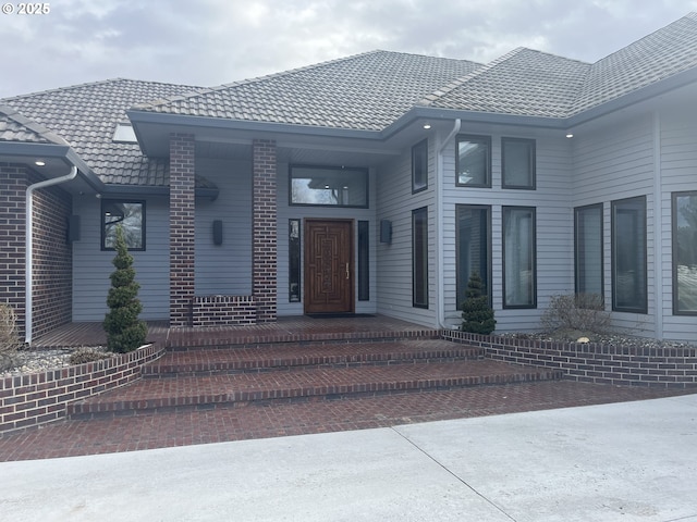 entrance to property featuring brick siding