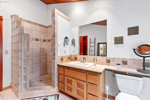 57953 Drury Ln, Blue River, OR 97413 - bathroom featuring tiled shower, vanity, vaulted ceiling, tile patterned floors, and toilet
