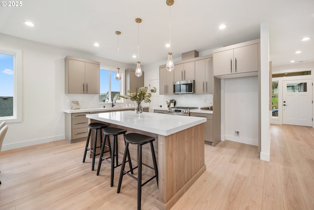 118 W 13th Way, La Center, WA 98629 - kitchen with appliances with stainless steel finishes, gray cabinets, a breakfast bar, light countertops, and a center island