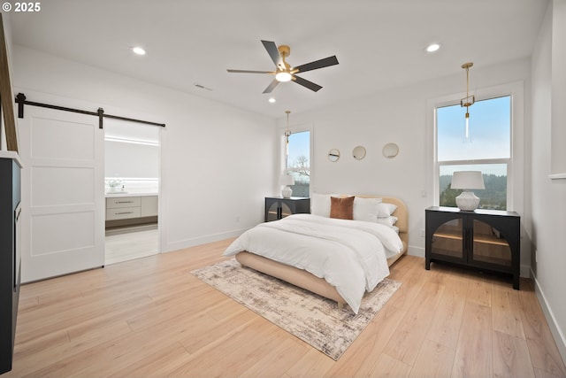 118 W 13th Way, La Center, WA 98629 - bedroom with a barn door, light wood-style floors, recessed lighting, baseboards, and ensuite bath