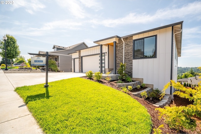 118 W 13th Way, La Center, WA 98629 - contemporary home with concrete driveway, board and batten siding, a garage, and stone siding