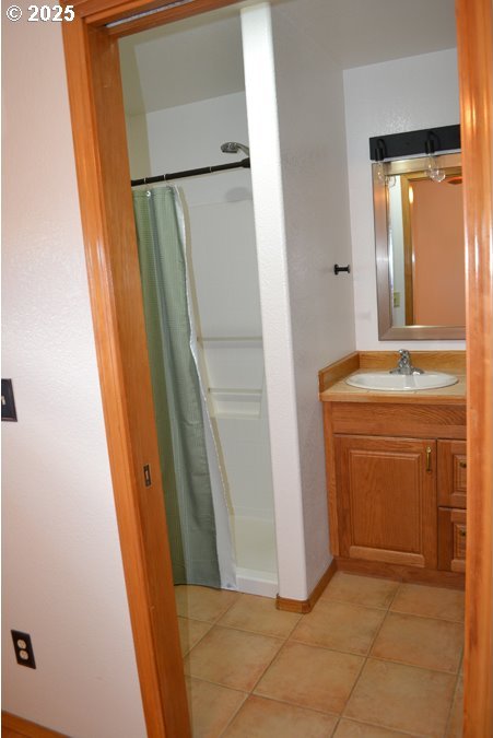 bathroom with baseboards, tile patterned flooring, a shower with curtain, and vanity