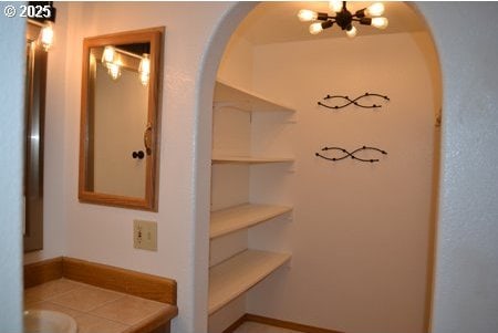 interior space with arched walkways and a chandelier