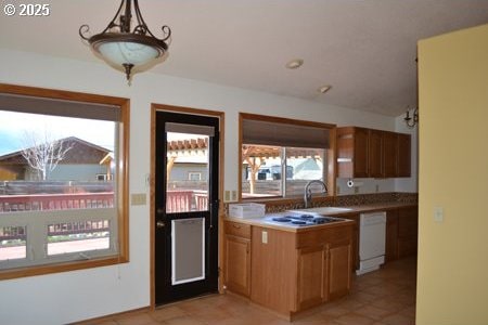 kitchen featuring white appliances, light tile patterned floors, and a sink