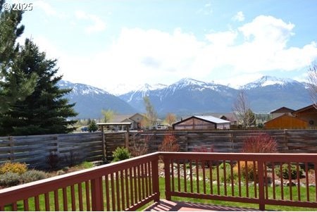 deck with a fenced backyard and a mountain view