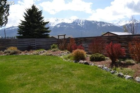 view of yard featuring fence and a mountain view