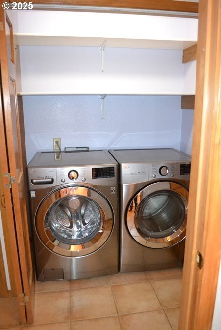 laundry area featuring tile patterned floors, laundry area, and washer and clothes dryer
