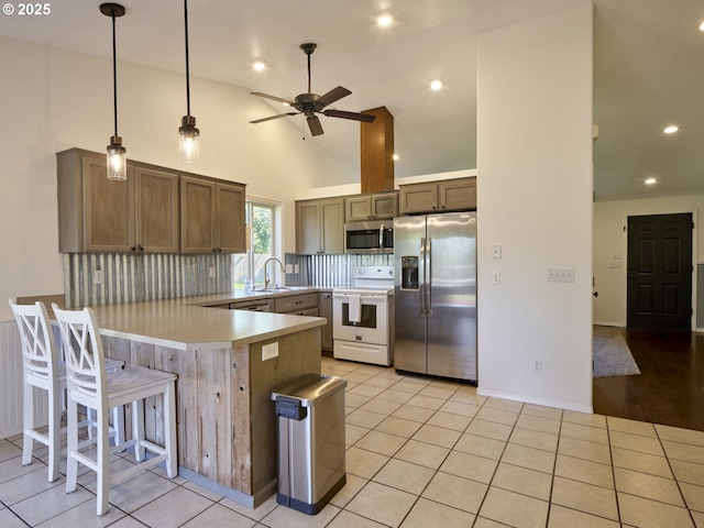503 E Yacolt Rd, Yacolt, WA 98675 - kitchen featuring appliances with stainless steel finishes, a peninsula, a ceiling fan, tasteful backsplash, and light countertops