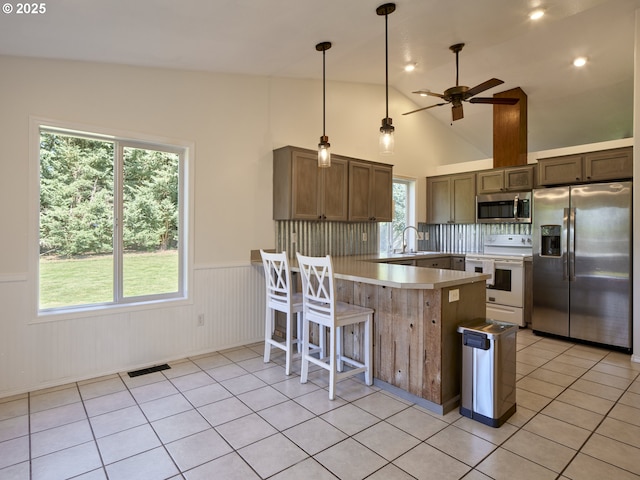 503 E Yacolt Rd, Yacolt, WA 98675 - kitchen with appliances with stainless steel finishes, a peninsula, a ceiling fan, wainscoting, and light tile patterned flooring