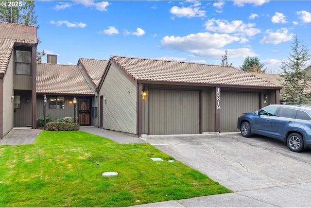 view of front of property with a garage, a tiled roof, a front yard, and driveway