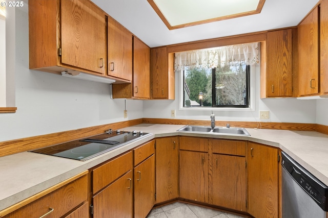 kitchen with black electric stovetop, a sink, light countertops, brown cabinets, and dishwasher