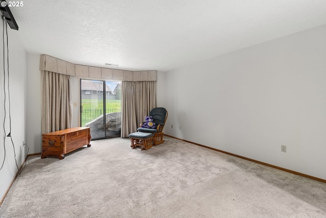 unfurnished room with carpet flooring, a textured ceiling, and baseboards