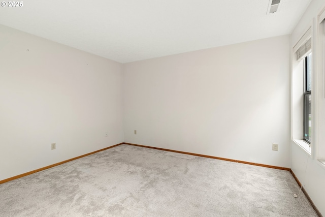 carpeted spare room with baseboards and a wealth of natural light