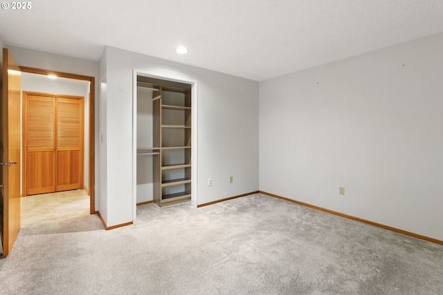 unfurnished bedroom with recessed lighting, a closet, carpet, and baseboards