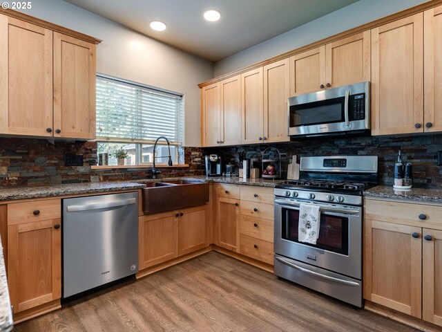 kitchen featuring stainless steel appliances, light brown cabinets, a sink, and recessed lighting