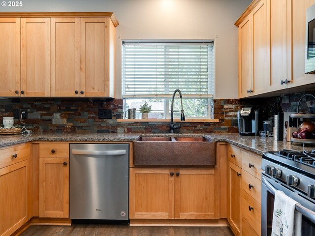 kitchen featuring stainless steel appliances, a sink, decorative backsplash, and light brown cabinets