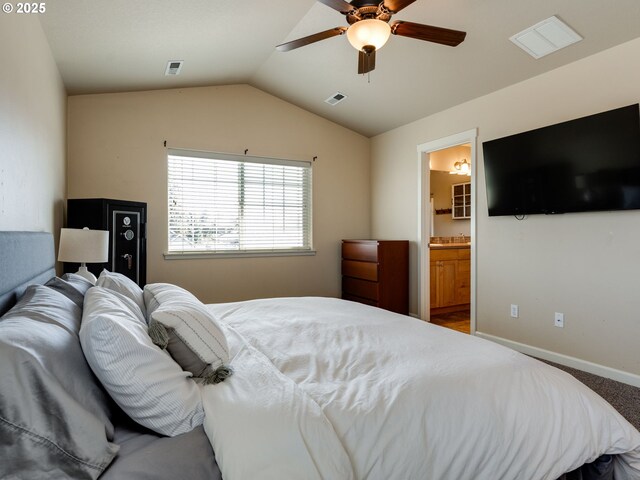 carpeted bedroom featuring vaulted ceiling, baseboards, ensuite bath, and a ceiling fan
