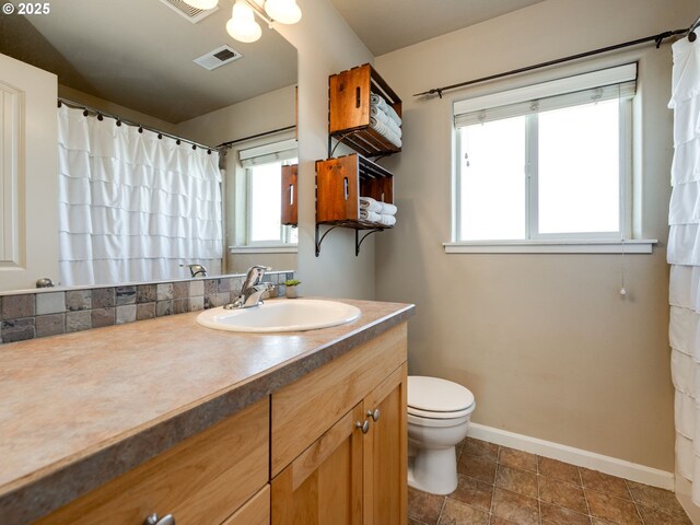 full bathroom featuring baseboards, toilet, and vanity