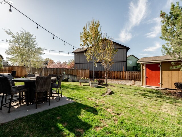 view of yard with a storage shed, an outdoor structure, and a patio area