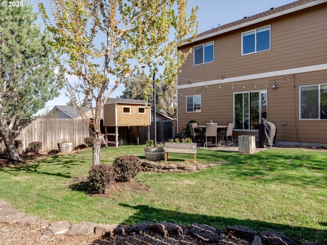 back of property with a patio area and a garden