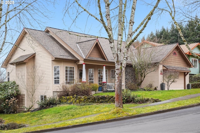 view of front of house featuring a porch, central air condition unit, roof with shingles, and a front lawn