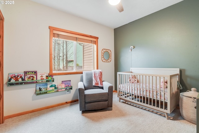 bedroom with ceiling fan, baseboards, carpet floors, and a crib