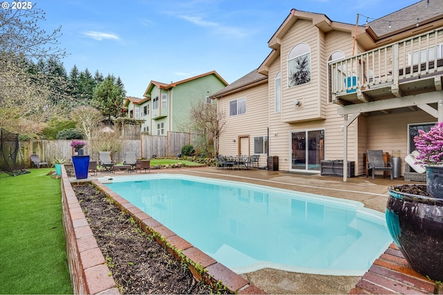 view of swimming pool with a patio, a lawn, a fenced in pool, and a fenced backyard