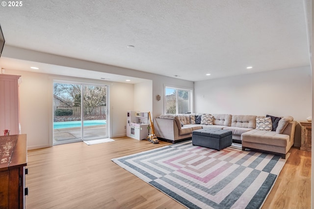 living room with recessed lighting, light wood finished floors, and a textured ceiling