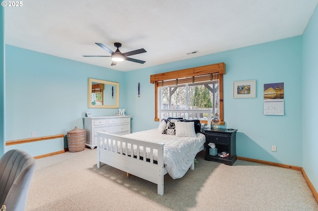 carpeted bedroom with visible vents, a ceiling fan, and baseboards