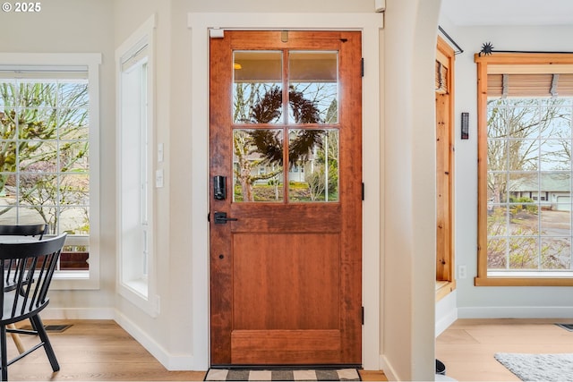 foyer with visible vents, light wood-style flooring, and baseboards