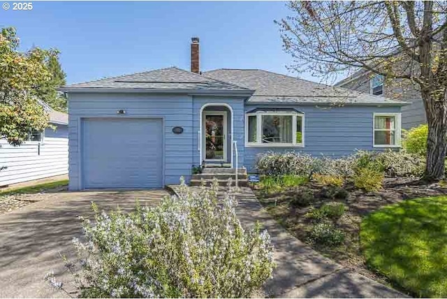 1910 Saginaw St S, Salem, OR 97302 - view of front of property featuring concrete driveway, a garage, a chimney, and roof with shingles