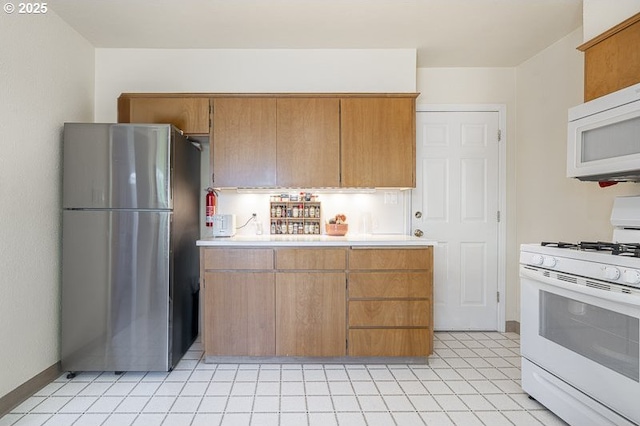 1910 Saginaw St S, Salem, OR 97302 - kitchen featuring white appliances, light countertops, brown cabinets, and baseboards