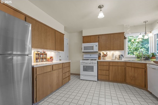 1910 Saginaw St S, Salem, OR 97302 - kitchen featuring white appliances, light countertops, a sink, decorative light fixtures, and brown cabinets