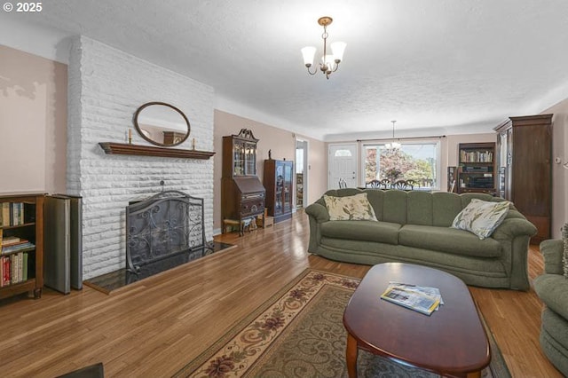 1910 Saginaw St S, Salem, OR 97302 - living area featuring a chandelier, wood finished floors, a textured ceiling, and a fireplace