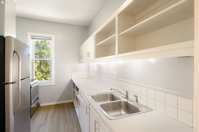 1963 Villard St, Eugene, OR 97403 - kitchen with stainless steel appliances, white cabinetry, light wood-style flooring, decorative backsplash, and light countertops